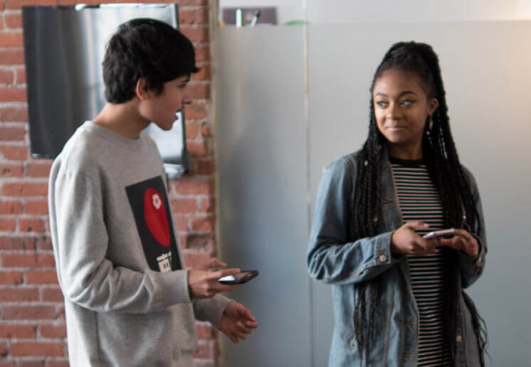 students-in-a-conference-room-discussing-the-nod-apps-research-and-design-while-holding-their-phones